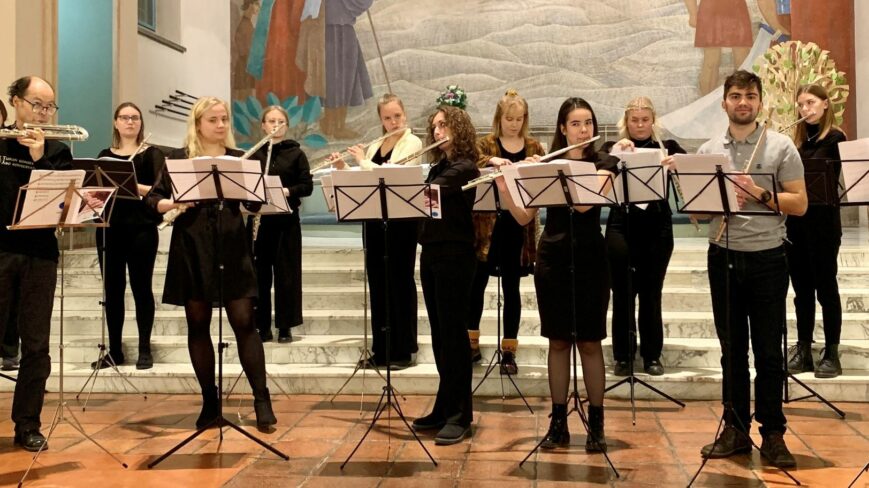 Kuvassa kolmetoistahenkinen huiluorkesteri huiluineen.